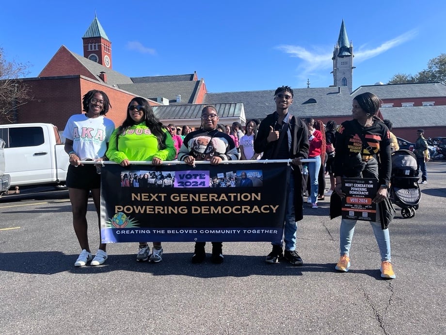 Young voters holding a banner that says "Next Generation Powering Democracy"