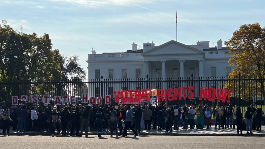 Protestors holding a "Voting Rights Now" sign at the White House