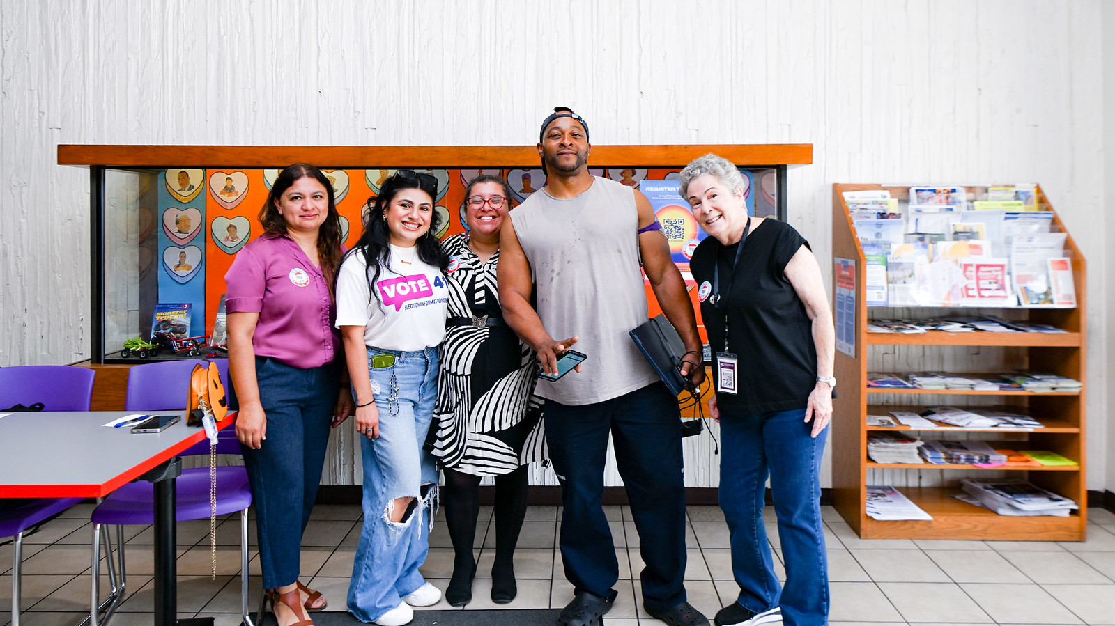 Five people at a voter registration event smiling