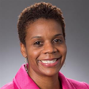 Headshot of a woman, Ayo Atterberry, in a pink shirt