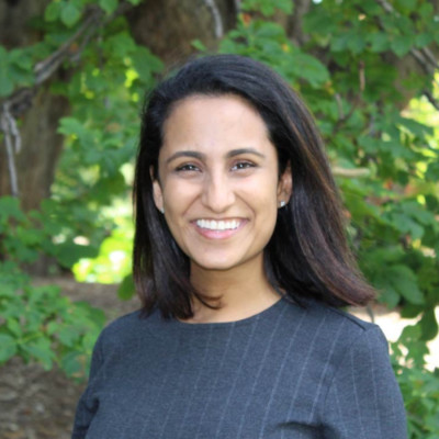 Headshot of Dhruti Tummalapalli in front of a nature scene