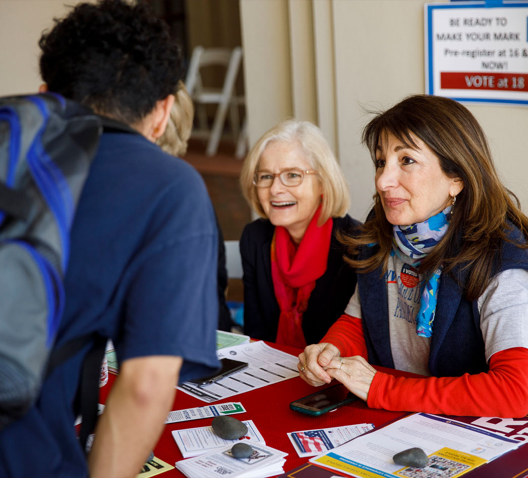 Two League members registering a young person to vote