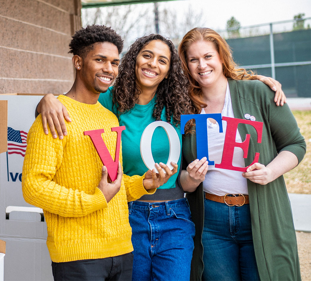 People holding letters that spell "VOTE"