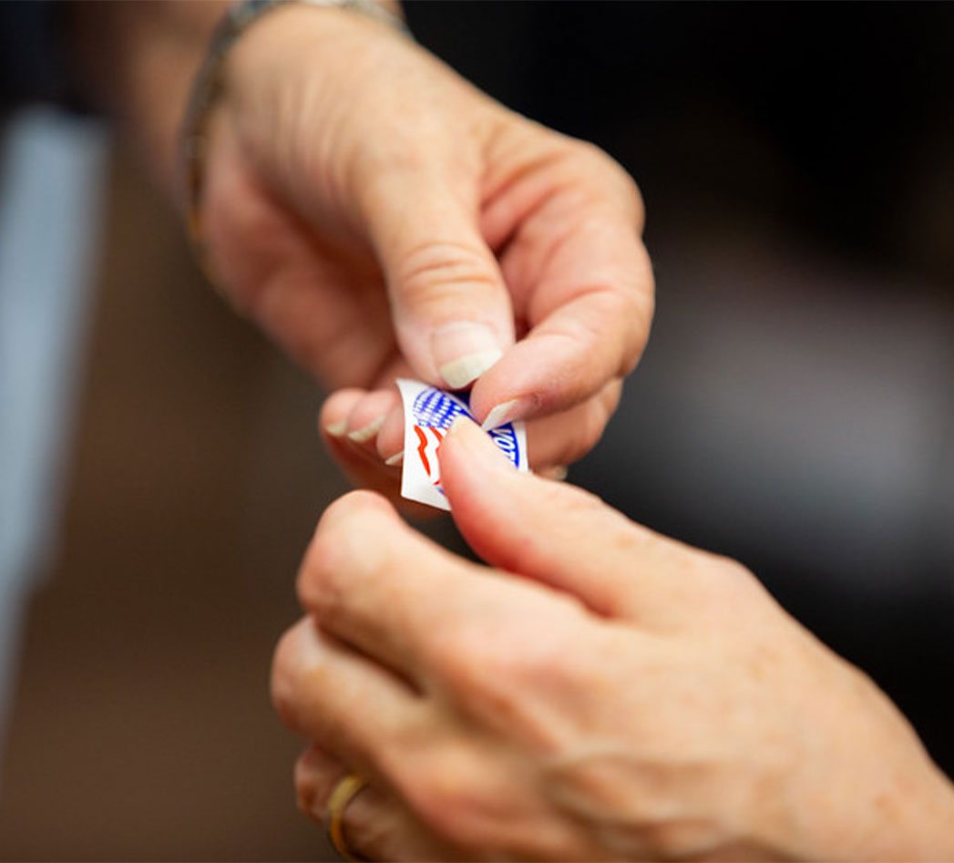 Two hands holding a voting sticker