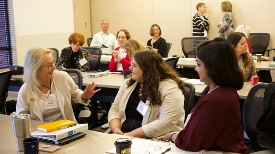 Women talking at conference room table during a training