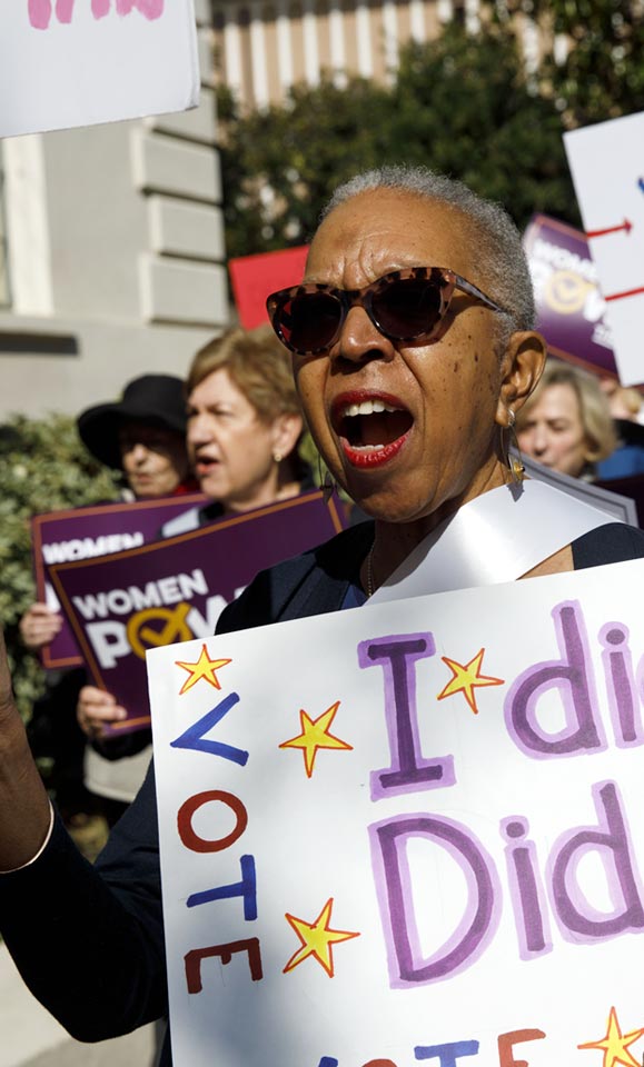 A woman marching to promote the vote