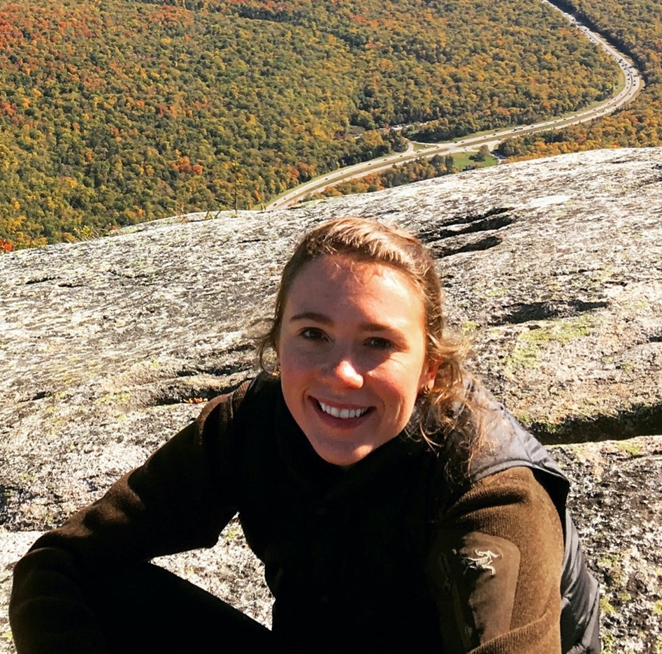 Headshot of Martina Berger, legal intern, sitting on a mountain