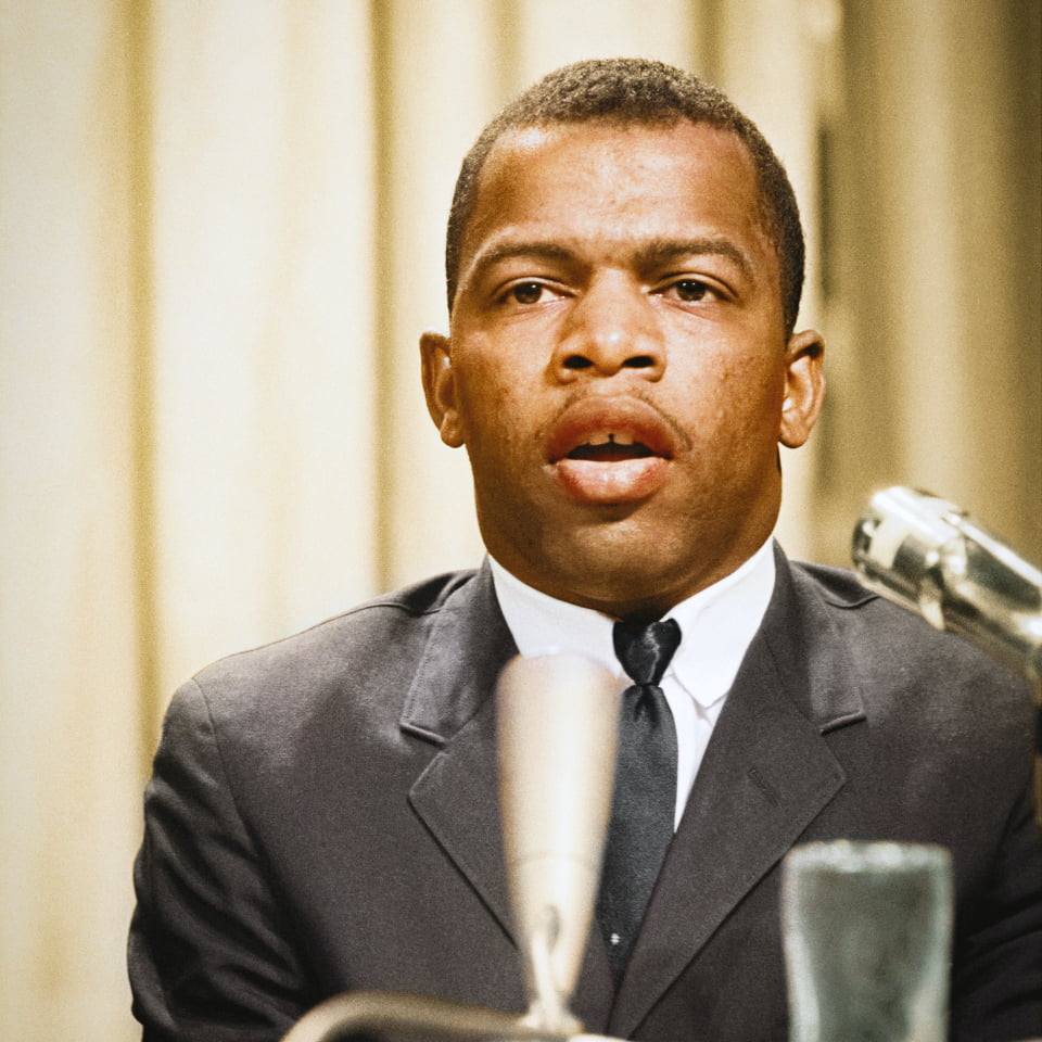 Image of a young John Lewis behind a microphone