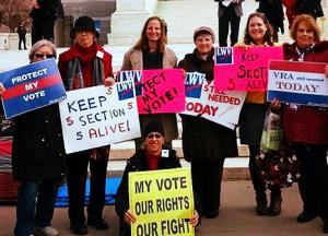 People standing and holding signs supporting voting rights