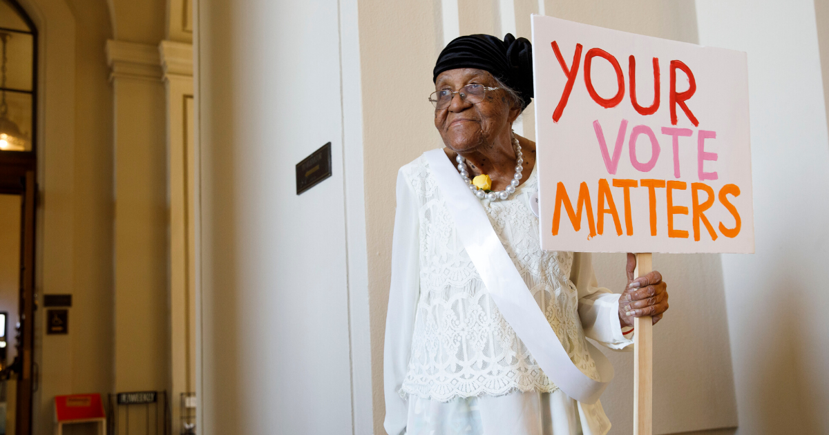Woman holding "Your vote matters" sign