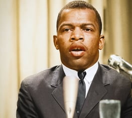 Image of a young John Lewis behind a microphone