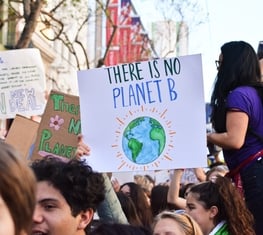 Protestor holding a sign that says "There's no planet B"