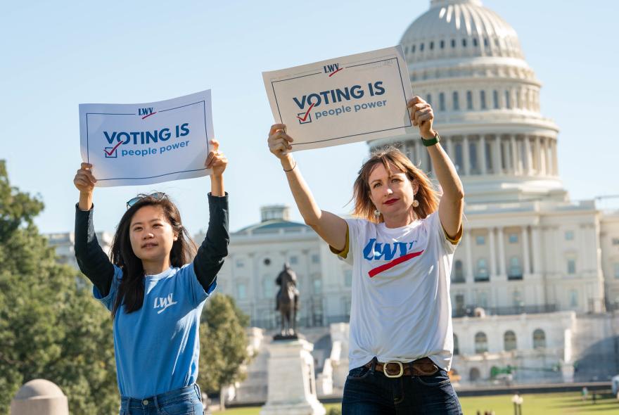 Women holding voting rights signs outside the US Capitol