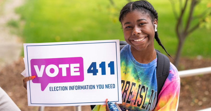 Young woman holding VOTE411 sign
