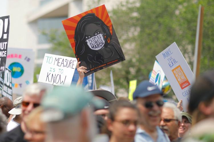 Protesters holding signs about climate change