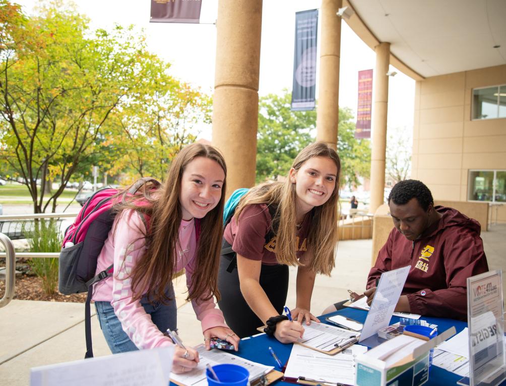 Two girls and a man registering to vote