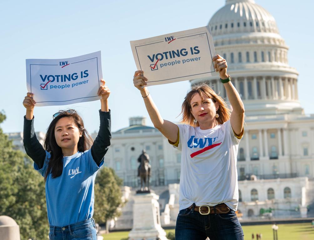 Women holding voting rights signs outside the US Capitol