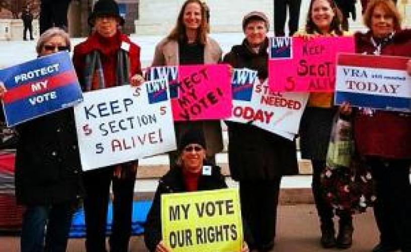 People standing and holding signs supporting voting rights