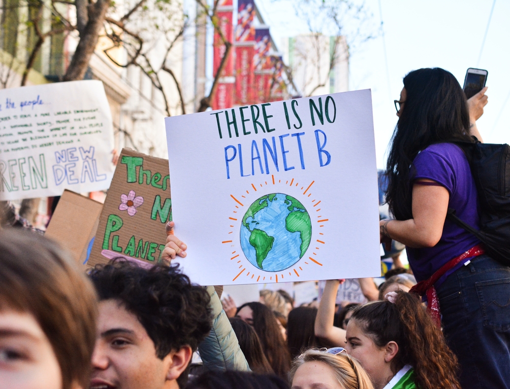Protestor holding a sign that says "There's no planet B"