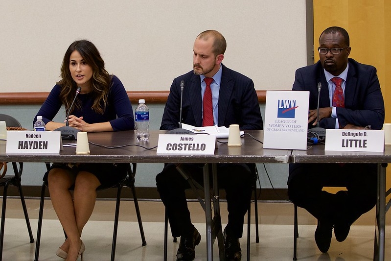 Three candidates seated at a forum