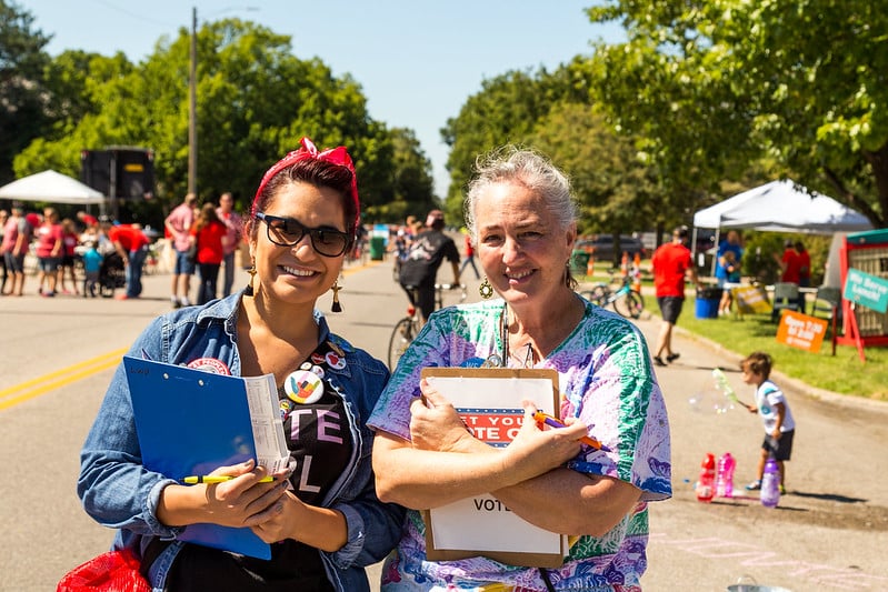 League volunteers holding clipboards at voter registration event