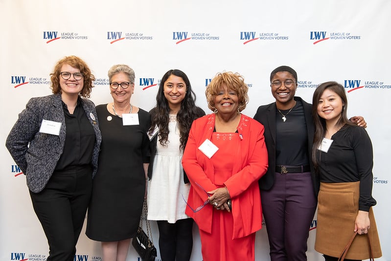 League members standing in front of a LWV branded step and repeat