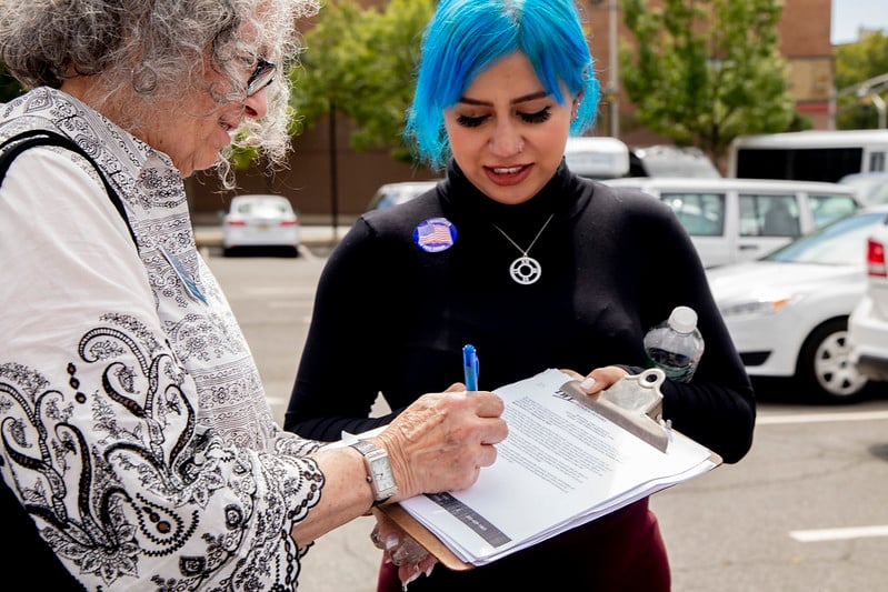 Woman registering to vote with clipboard at NVRD event
