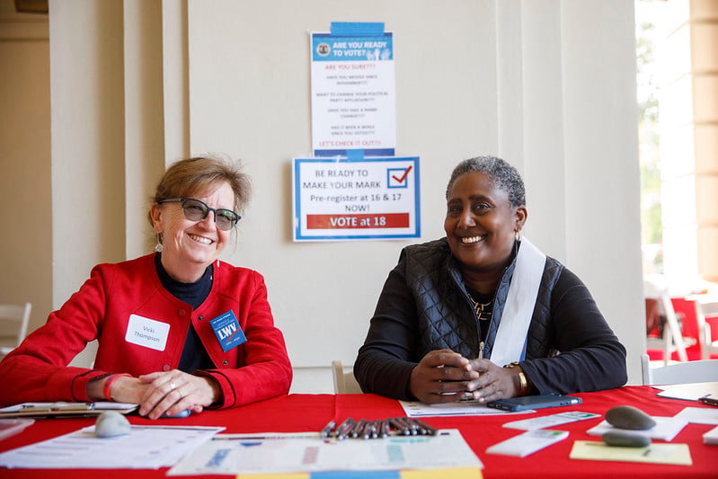 Two League members at a voter registration table