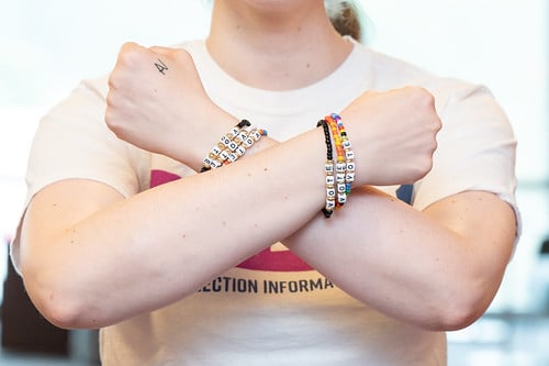 Woman with multiple voting-themed friendship bracelets on both wrists