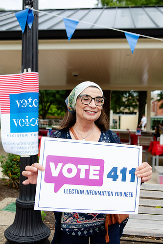 A woman holding a VOTE411 sign