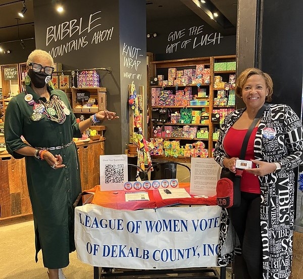 Women at a voter registration table in a LUSH store