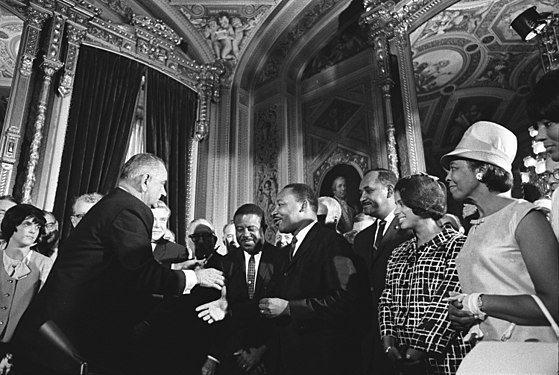 President Lyndon B. Johnson shakes Dr. Martin Luther King Jr's hand at the signing of the Voting Rights Act