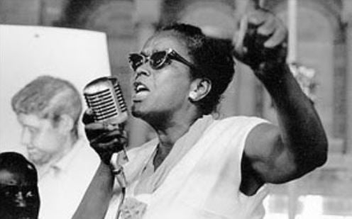 Ella Baker speaking into a microphone