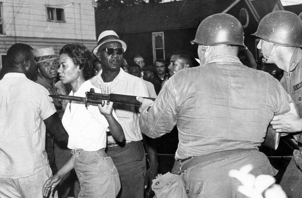 Gloria Richardson moving a law enforcement officer's gun away from her
