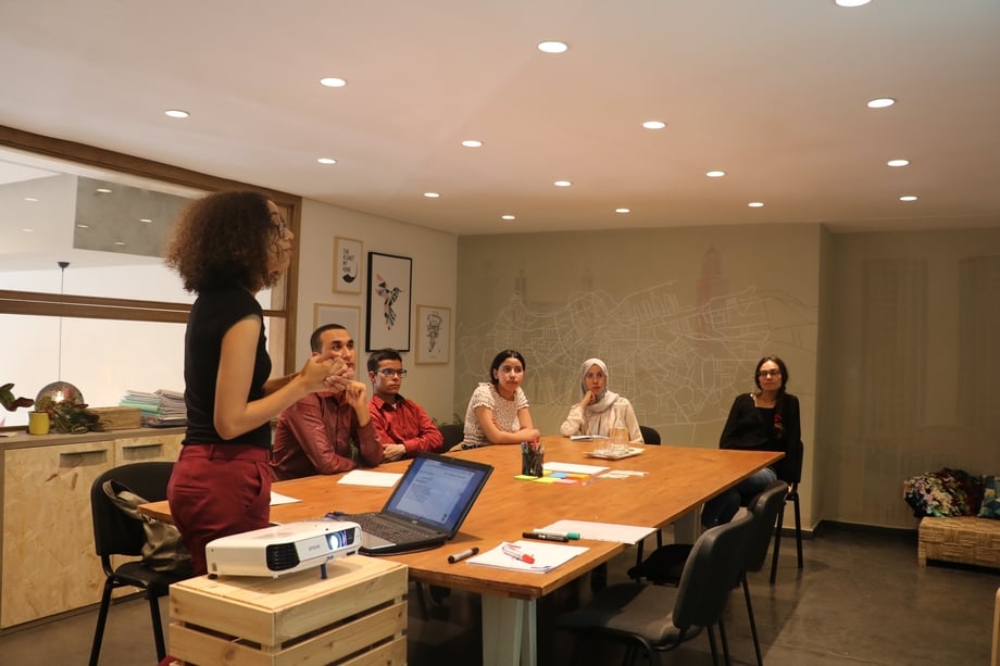 People sitting around a wooden table discussing an issue