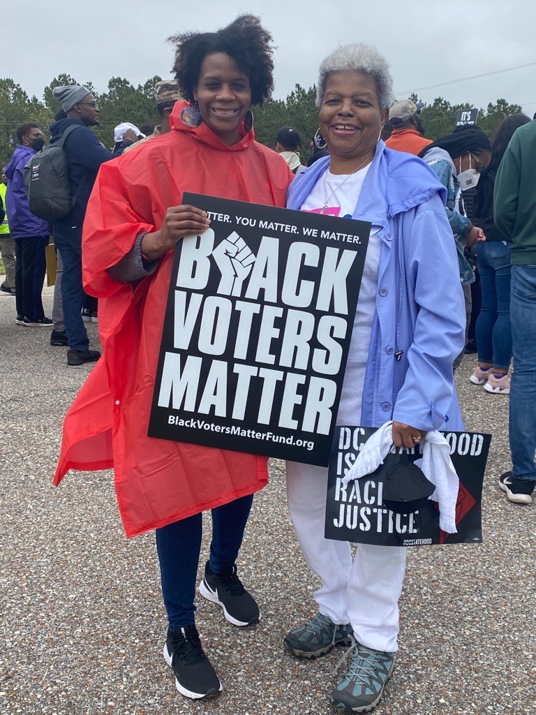 Dr. Turner and Ayo Atterberry at a march. Ayo holds a "Black Voters Matter" sign.
