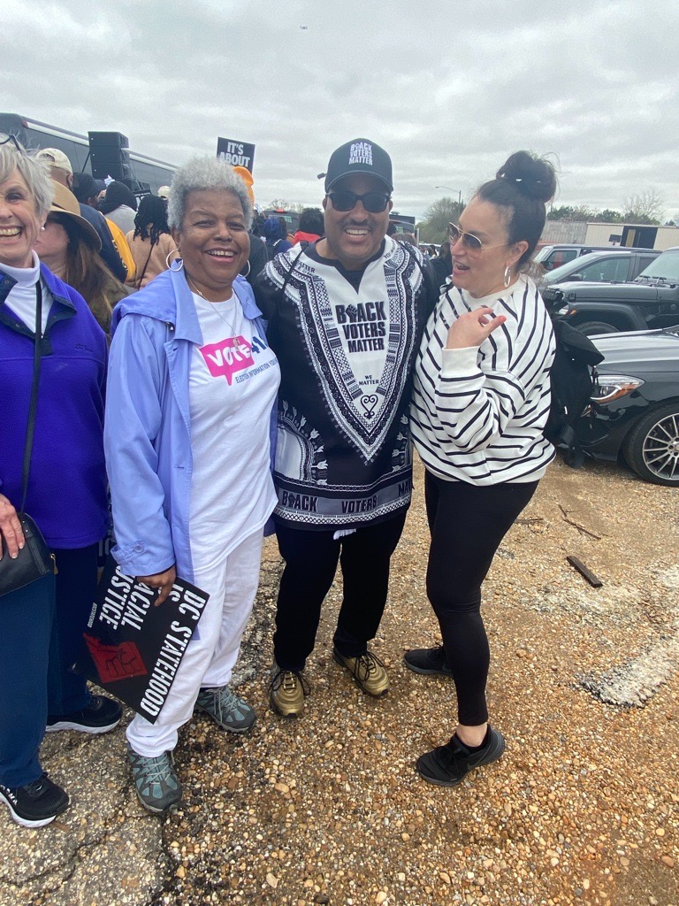 Dr. Turner and former CEO Virginia Kase Solomon laughing at a rally with a partner