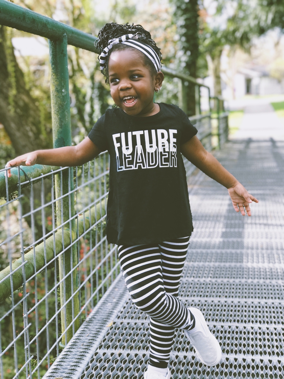 A young girl wearing a shirt that says "Future Leader"