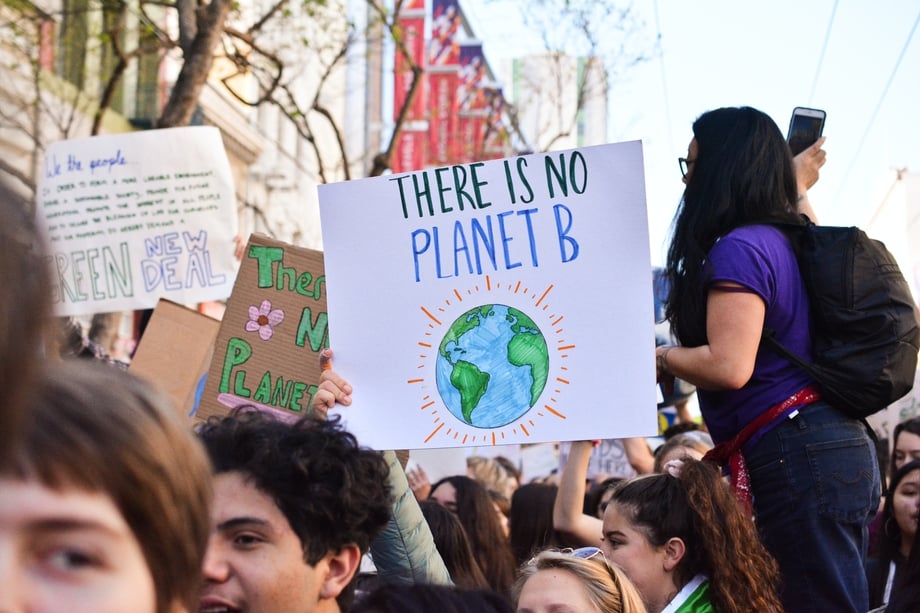 Protestor holding a sign that says "There's no planet B"