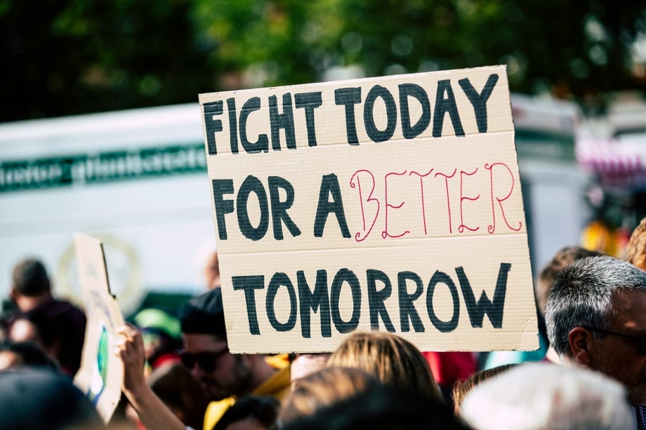 Person holding a protest sign that says "fight today for a better tomorrow"