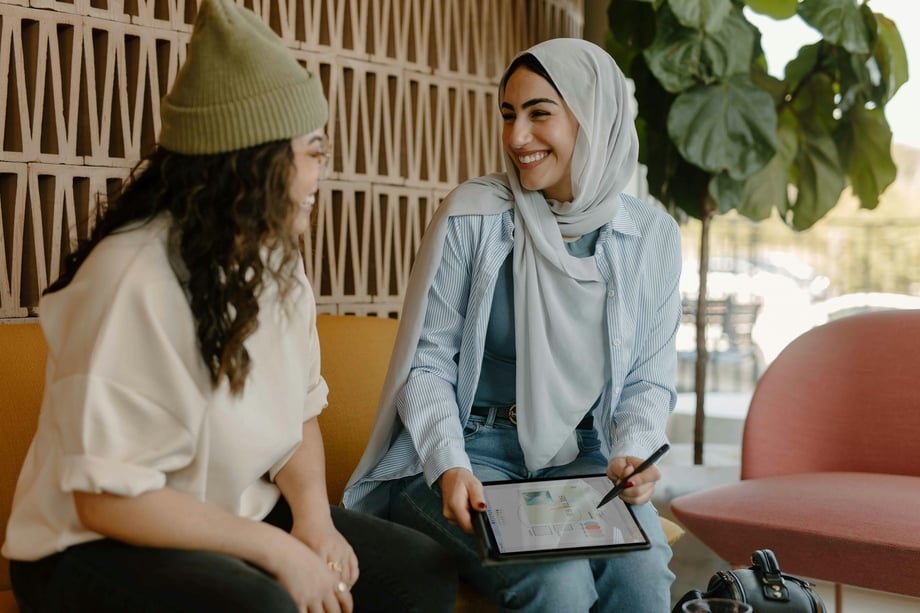 Two people, one holding an ipad, in an office space
