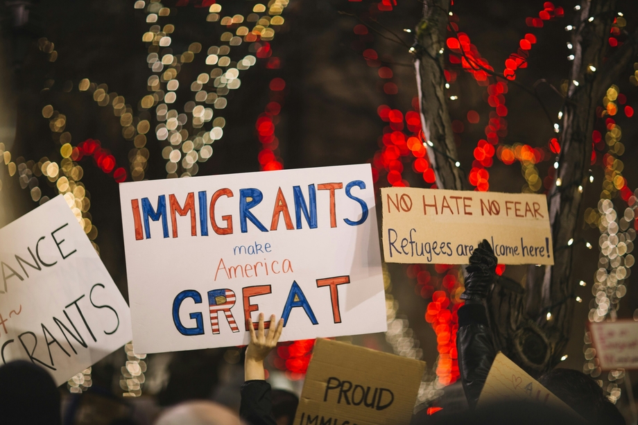 Protestors holding up pro-immigration signs such as "immigrants make America great"