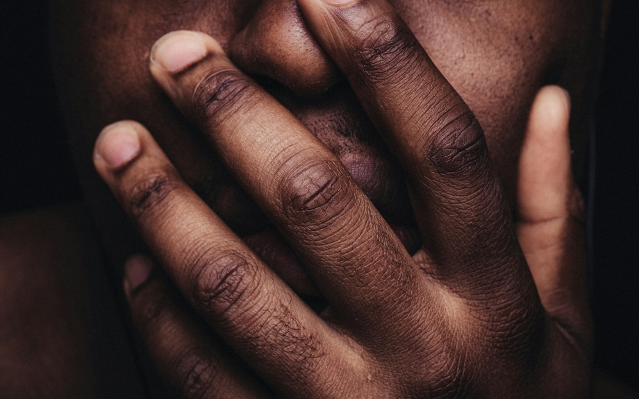 Close up of a person holding their hand over their mouth