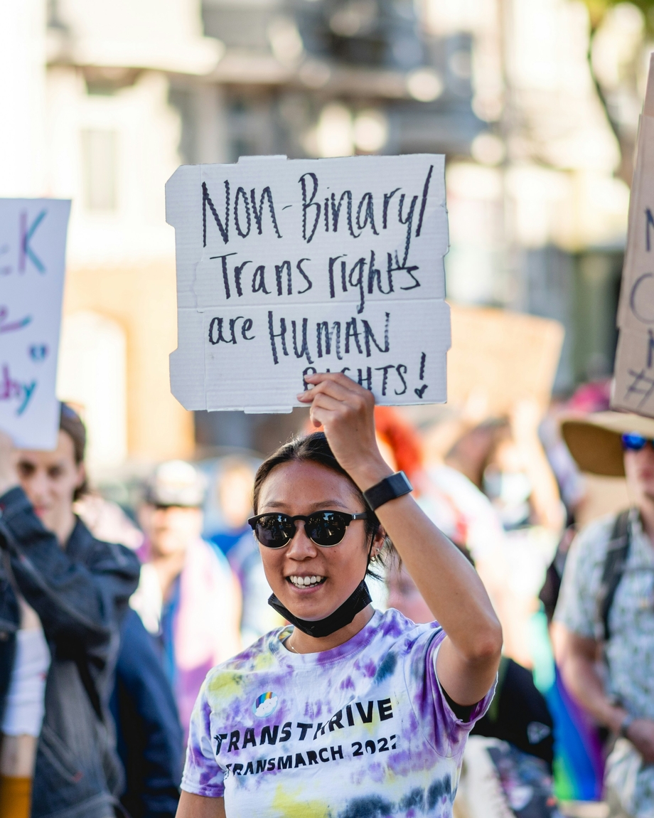 A person with a sign that says "nonbinary trans rights are human rights"