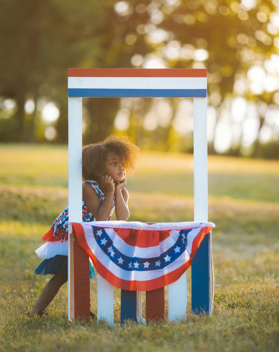 Kid standing at a booth with her head in her hands