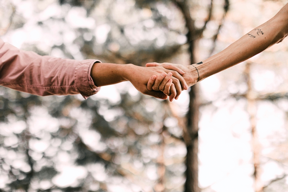 Two people holding hands in the outdoors