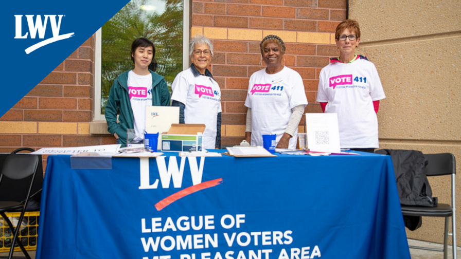 Four LWV members standing outside a registration booth