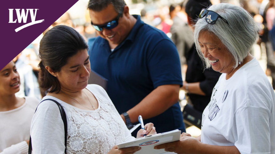 Women helping another woman register to vote