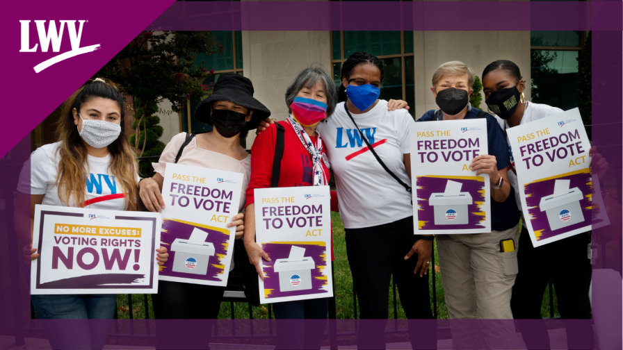 Six women holding Freedom to Vote Act signs