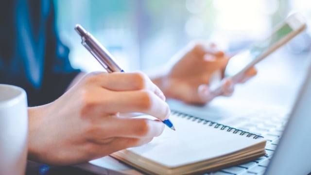 Person writing in notebook - Talking Points